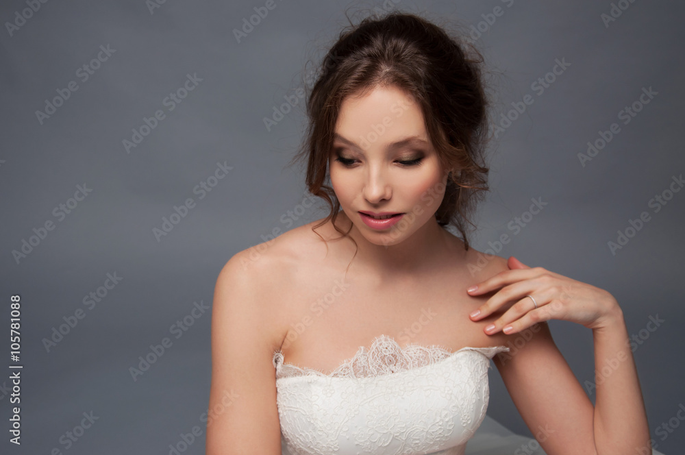 Adorable young bride with brown curly hair sitting in a cloud of Adorable young bride with brown curly hair sitting in a cloud of