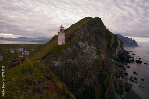 Lighthouse over the sea on a rocky ridge. The Sea of Okhotsk. Peninsula Kony. Magadan Region. Russia. photo