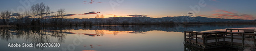 Panoramic view Wooden platform overlooking a Large Lake with the reflection of a snowed peaked mountain photo