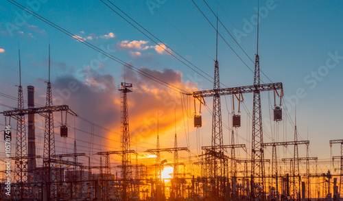 distribution electric substation with power lines and transformers, at sunset
