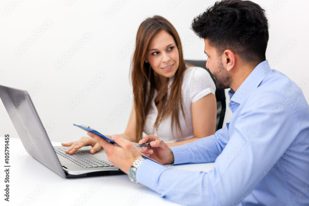 Smiling business people using a laptop computer in their office Smiling business people using a laptop computer in their office
