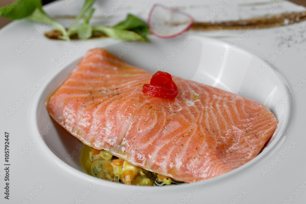 fish cooked with spices, butter and vegetables, lined in white plate fish cooked with spices, butter and vegetables, lined in white plate