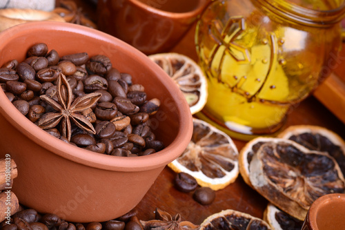 orange and lemon, coffee beans and cinnamon on wooden brown background.