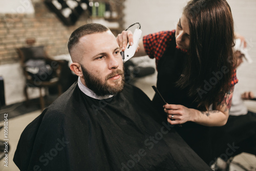 Bearded hipster client visiting barber shop 