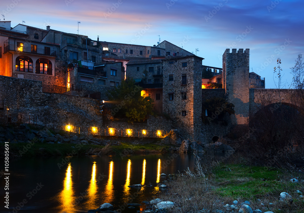 Evening photo of medieval town on banks of river. Besalu