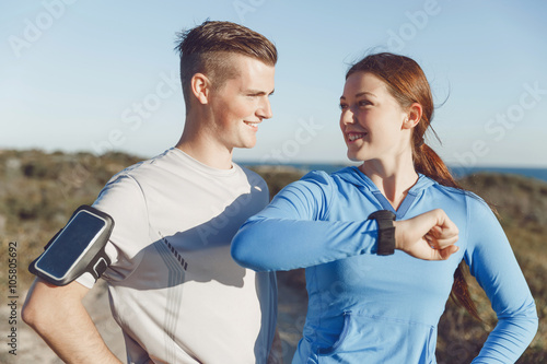 Runner woman with heart rate monitor running on beach