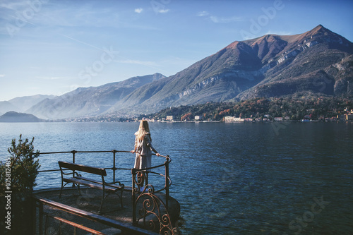 girl standing at the bench on the waterfront of Lake Como