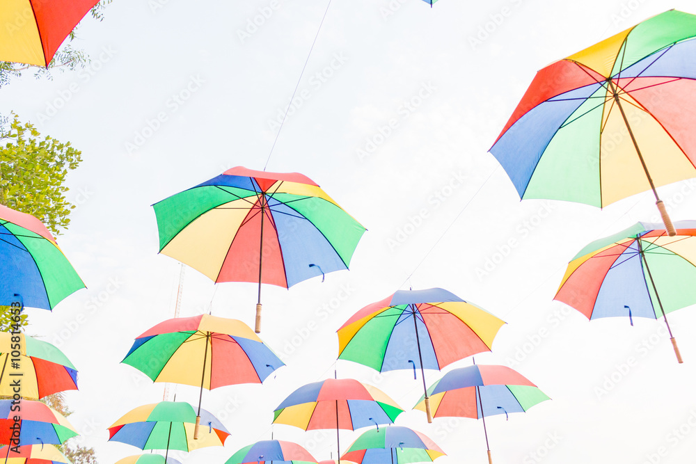 Obraz premium Rainbow umbrella on sky background