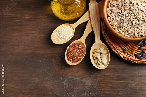 Sunflower oil and seeds on wooden table background, closeup