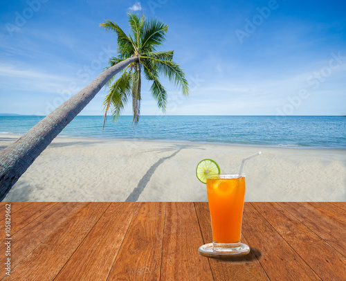 Lemon tea on the wood table in luxury beach and coconut tree © fongleon356