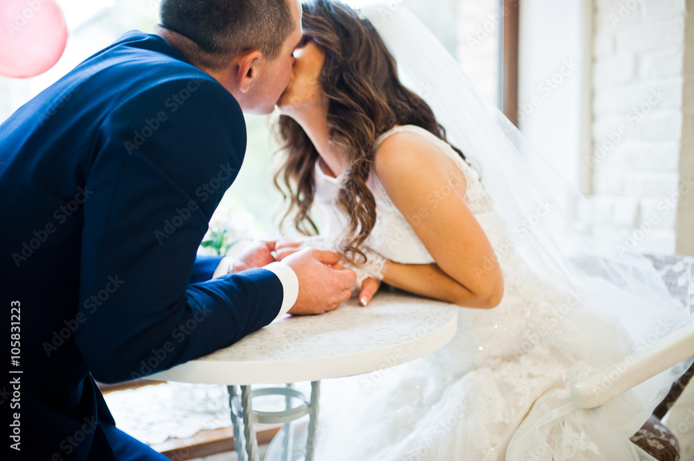 Wedding couple sitting at a table in a cafe Wedding couple sitting at a table in a cafe