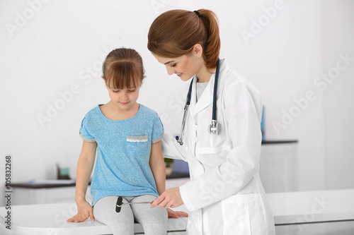 Doctor examining little gir...