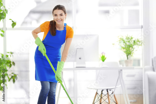 Woman cleaning with mop ind...