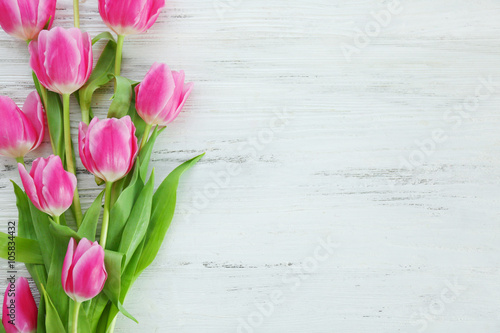 Fototapeta Naklejka Na Ścianę i Meble -  Fresh pink tulips on a wooden table, top view