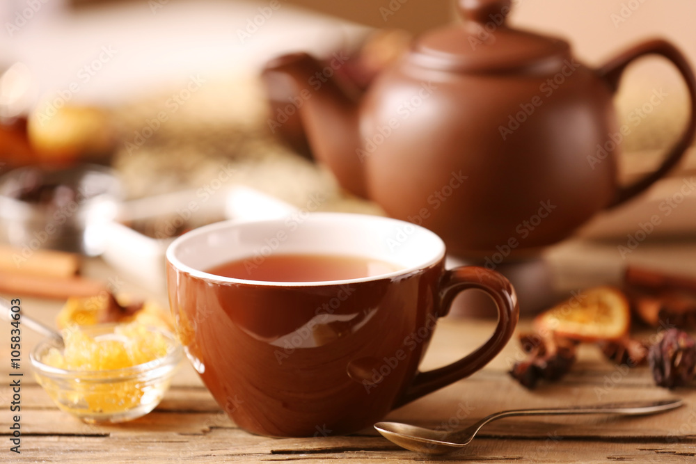 Cup of tea with spices and honey on wooden table closeup