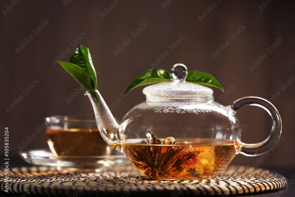 Cup of tea and teapot on a wicker mat Cup of tea and teapot on a wicker mat
