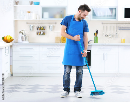 Man sweeping floor in the kitchen