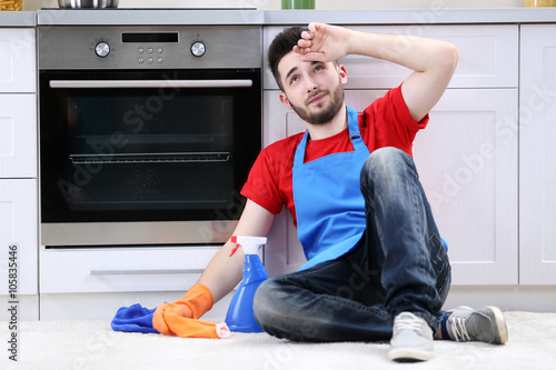 Tired man sitting on floor ...