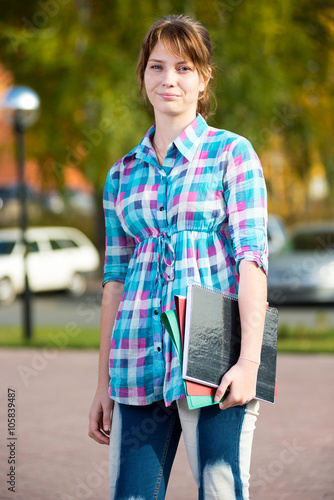 Portrait of young alluring woman holding education books. Student girl. © mr.markin