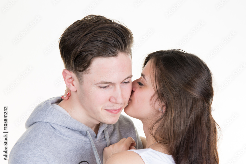 Close up of cute girl kissing her boyfriend. Isolated on white. Close up of cute girl kissing her boyfriend. Isolated on white.