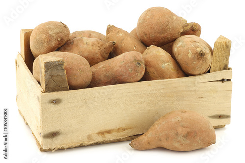 sweet potatoes in a wooden crate on a white background