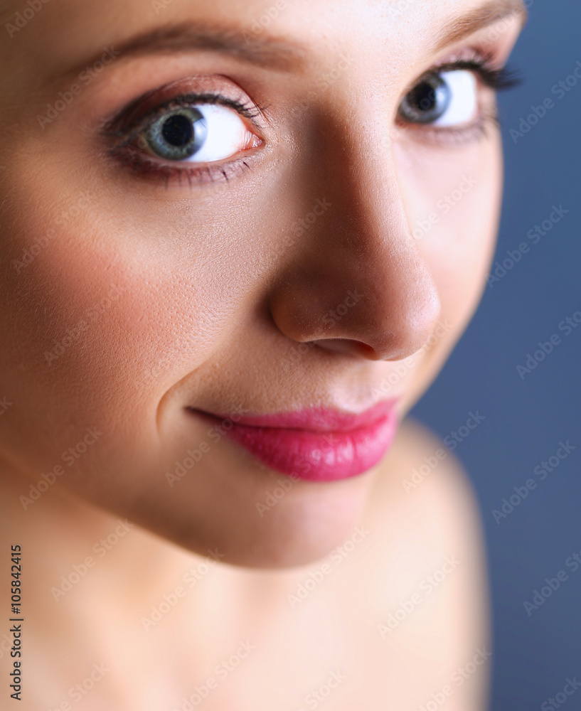 Fototapeta premium A beautiful woman, portrait isolated on blue background