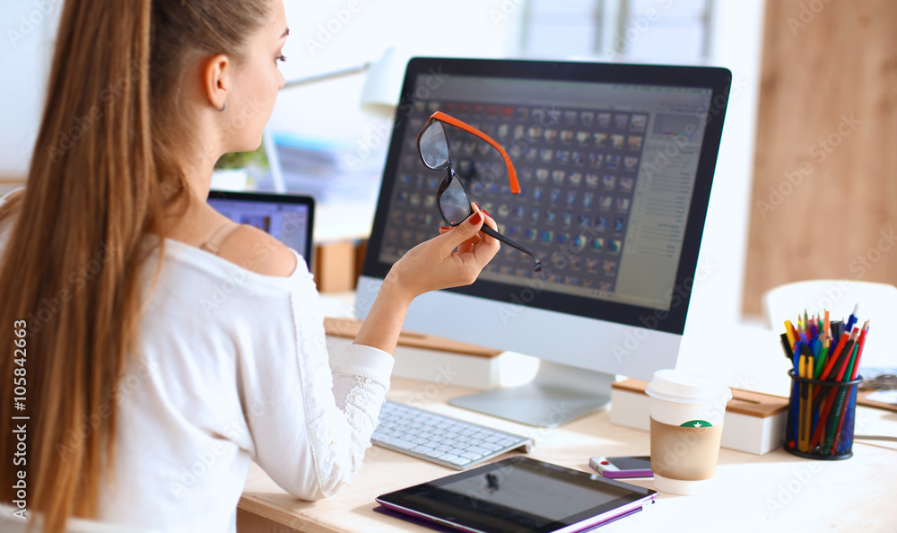 Young woman working in office, sitting at desk Young woman working in office, sitting at desk
