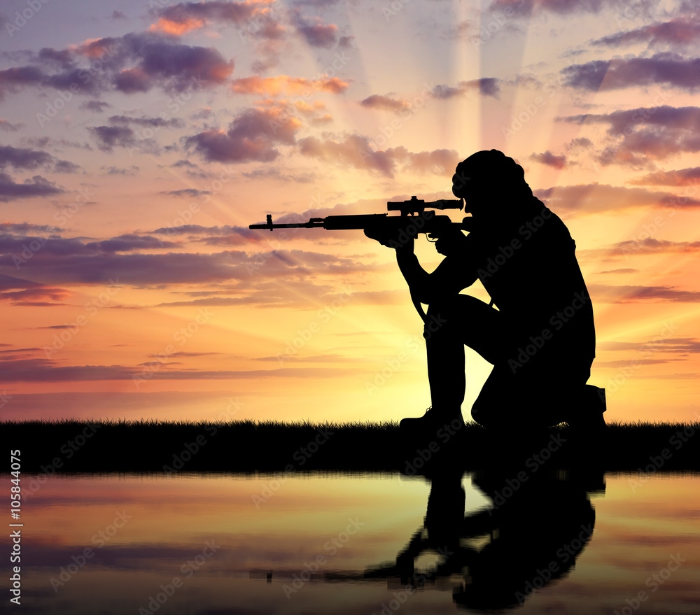Silhouette of man aiming with rifle during sunset Silhouette of man aiming with rifle during sunset