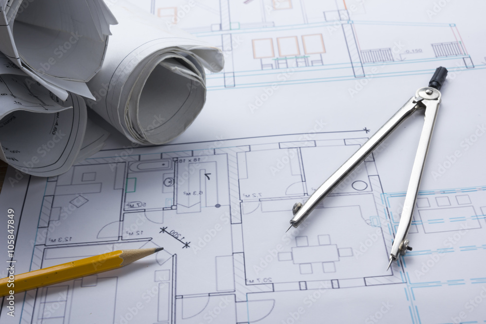 Architect worplace top view. Architectural project, blueprints, blueprint rolls and divider compass, pencil on plans. Construction background. Engineering tools. Copy space Architect worplace top view. Architectural project, blueprints, blueprint rolls and divider compass, pencil on plans. Construction background. Engineering tools. Copy space