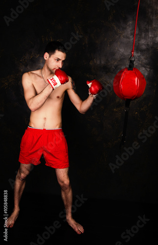 Boxer with red gloves in dark room