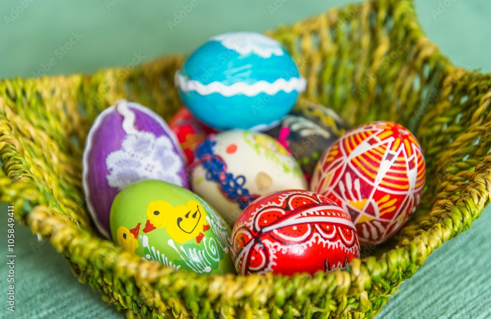 Fototapeta premium Beautiful colorful hand painted easter eggs in basket. Selective focus
