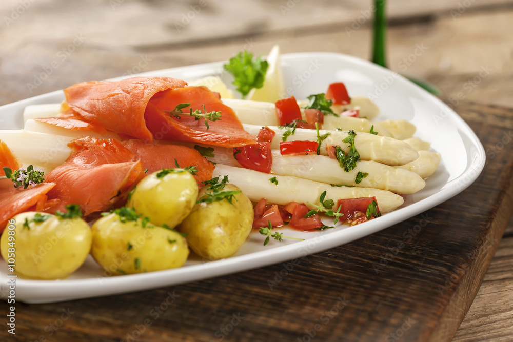 Spargel mit Sauce Vinaigrette, Lachs und Kartoffeln auf weißem Teller Spargel mit Sauce Vinaigrette, Lachs und Kartoffeln auf weißem Teller
