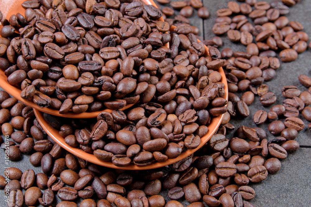 Fototapeta premium coffee beans in an orange plate on a dark stone background