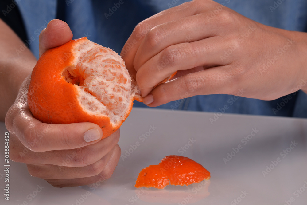 Pelando una mandarina, quitando concha a una mandarina. Stock