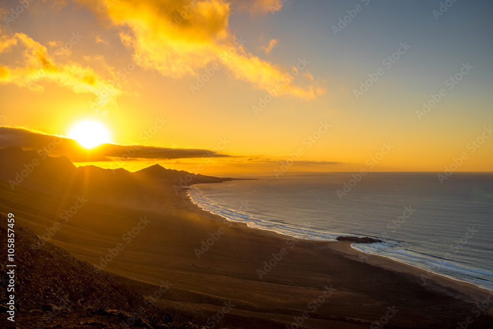 Top view on Cofete beach and mountains on Jandia peninsula on Fuerteventura island on the sunset in Spain - obrazy, fototapety, plakaty 