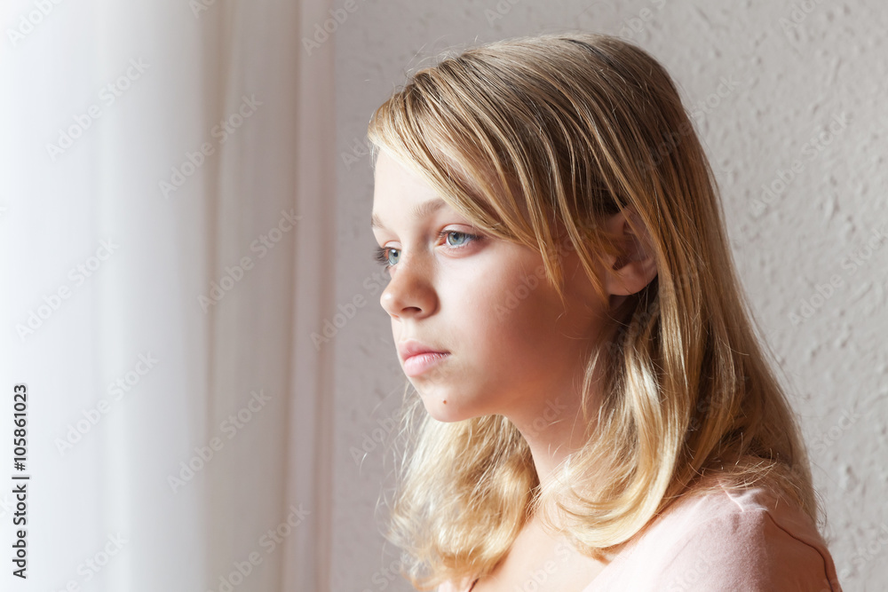 Caucasian girl near a window with white curtains Caucasian girl near a window with white curtains