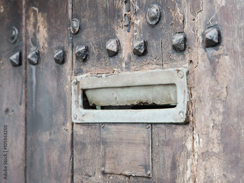 Ancient iron letterbox slot on brown wooden background, vintage style, intentionally blurred. Ancient iron letterbox slot on brown wooden background, vintage style, intentionally blurred.