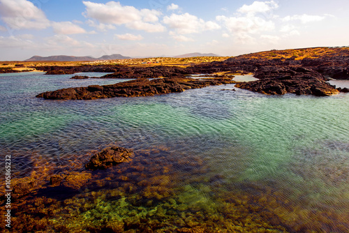 Volcanic coast with colorful water on the nothern part of Fuerteventura island near El Cotillo village in Spain