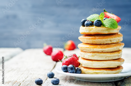 pancakes with honey, strawberries and blueberries