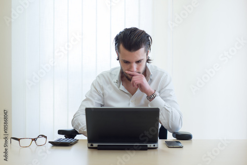 Young and successful businessman typing on his laptop