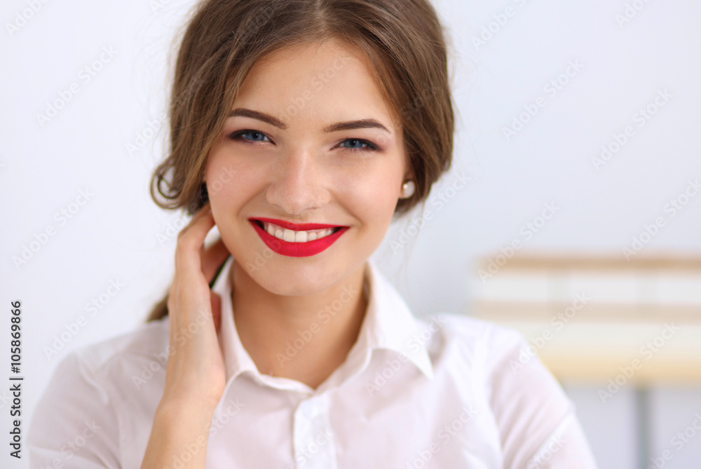 Attractive businesswoman standing near wall in office Attractive businesswoman standing near wall in office