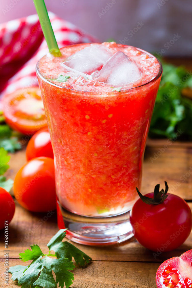 Gass of tomato smoothie, fresh tomatoes and cilantro on a dark wooden background . Vegetarian or healthy eating concept Gass of tomato smoothie, fresh tomatoes and cilantro on a dark wooden background . Vegetarian or healthy eating concept
