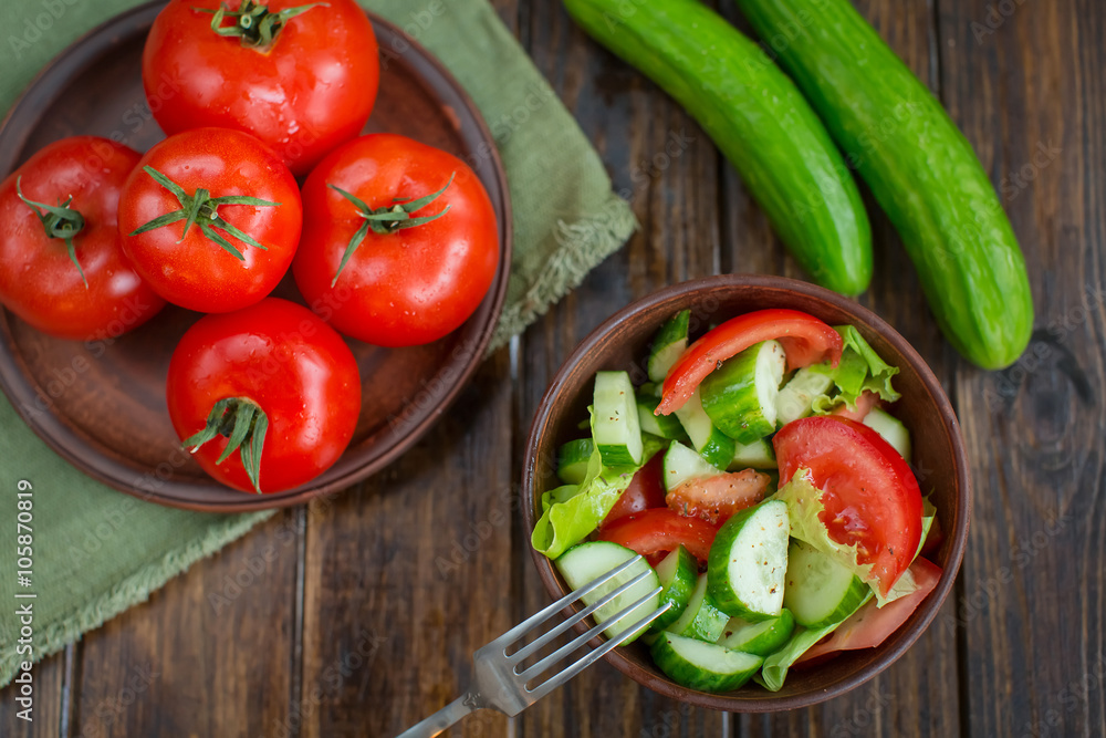 spring vegetables. tomatoes, cucumbers and lettuce on a wooden b spring vegetables. tomatoes, cucumbers and lettuce on a wooden b