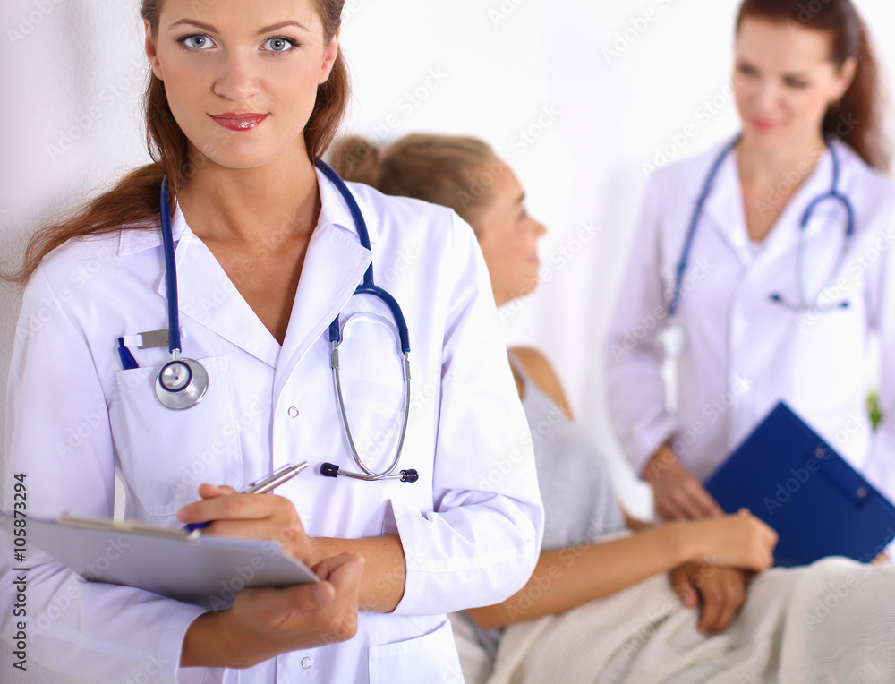Smiling female doctor with a folder in uniform standing at hospital Smiling female doctor with a folder in uniform standing at hospital
