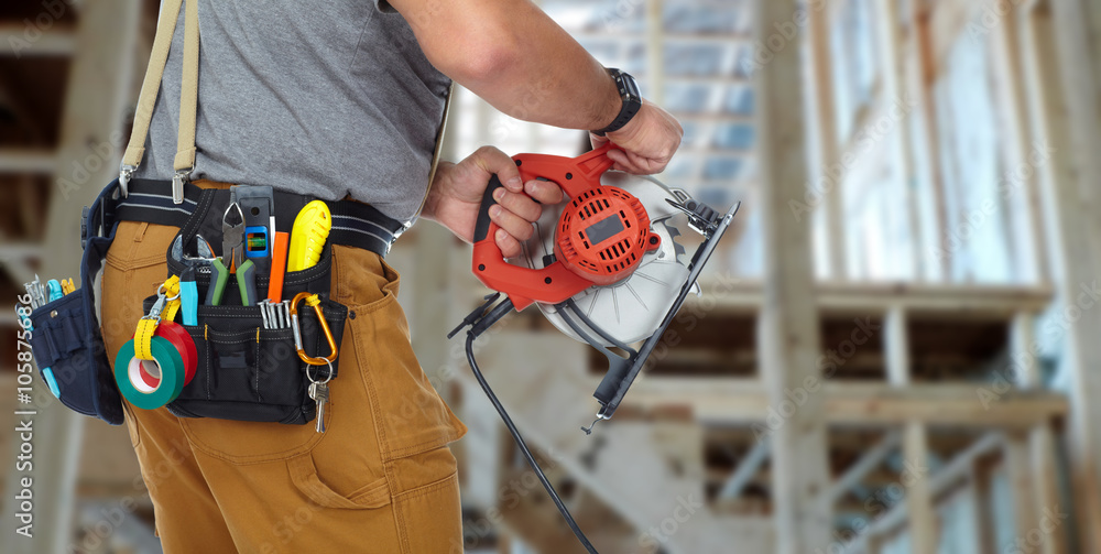 Hands of construction builder with electric saw. Hands of construction builder with electric saw.