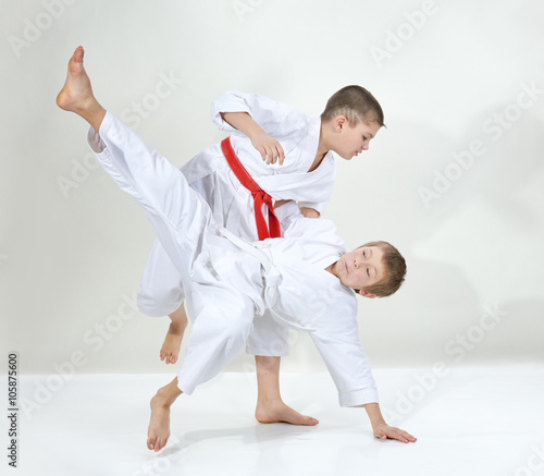 Sportsmen in kimono with different belts trained throws technique