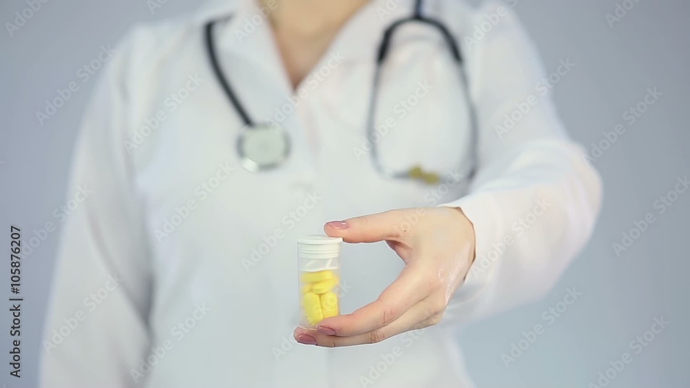 Female doctor offering a bottle of pills or vitamin supplements, drugstore Female doctor offering a bottle of pills or vitamin supplements, drugstore