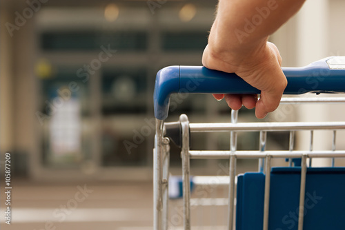 Woman driving shopping cart in front of the supermarket