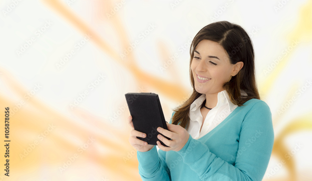 Beautiful girl smiling reading on a table portrait on orange abstract background Beautiful girl smiling reading on a table portrait on orange abstract background