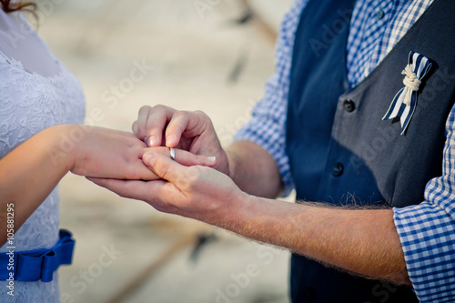 The groom puts on a wedding ring the bride's finger